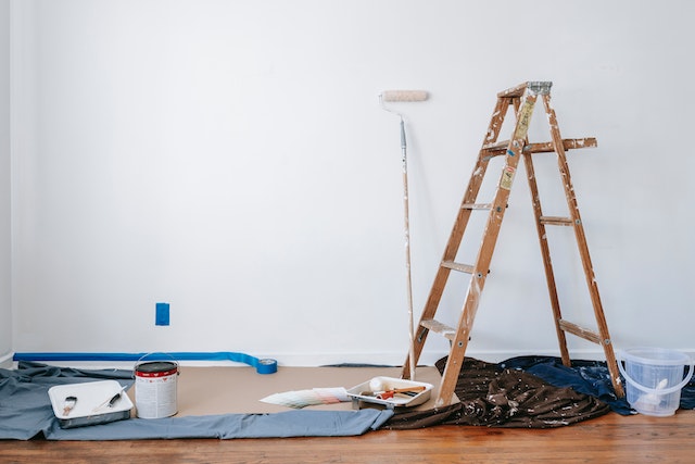 Brown wooden ladder next to painting materials