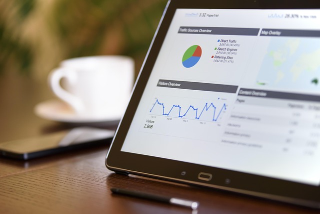 Tablet showing website marketing analytics dashboard with charts and graphs on a desk
