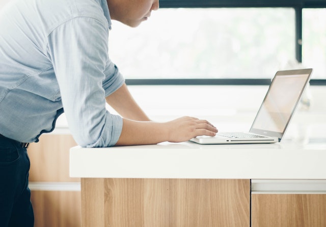  a person bent over a laptop working