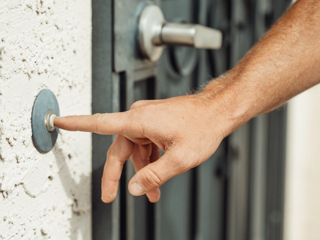  close up on a hand ringing a doorbell