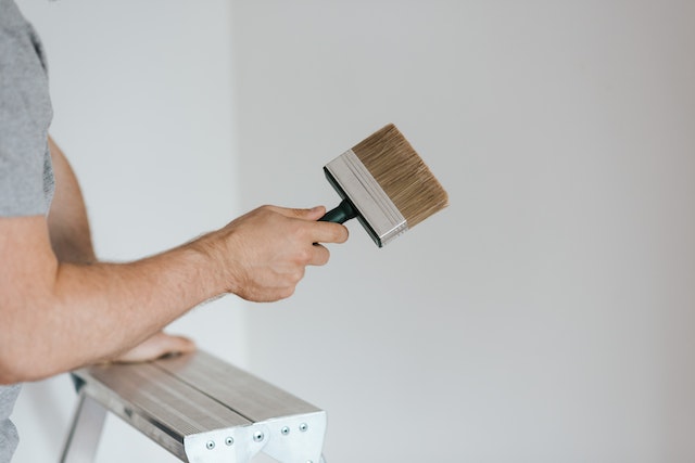 landlord-with-paintbrush-in-hand-painting-white-wall