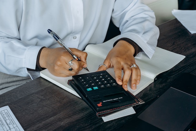 landlord-writing-on-notepad-with-calculator-on-desk