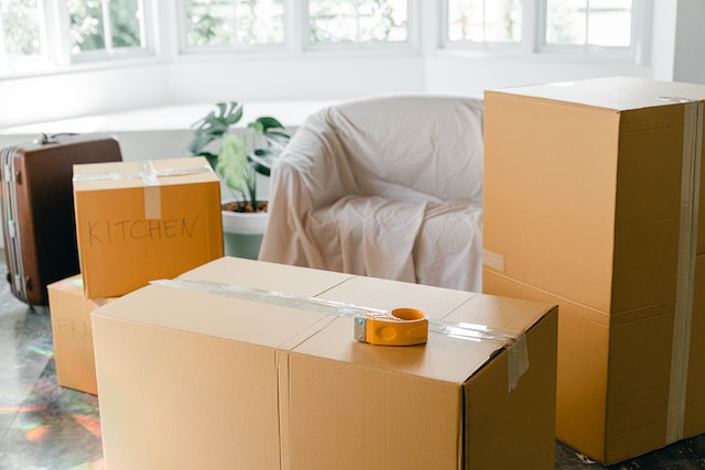 packed boxes sitting in front of a covered couch