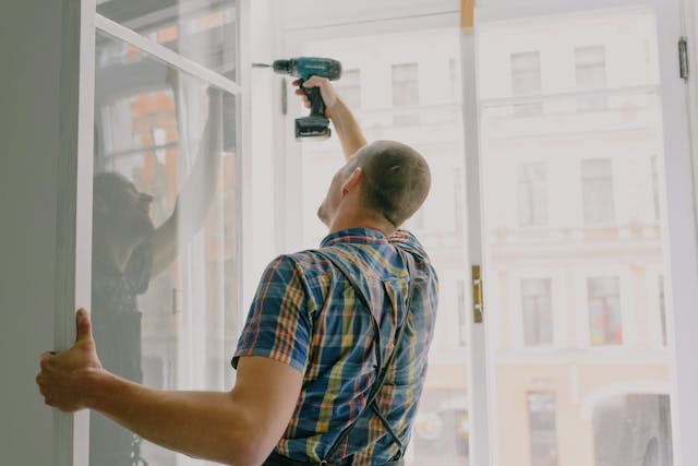 person drilling into open window pane