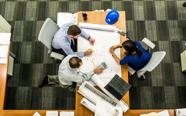 construction team gathered around a table looking at blueprints