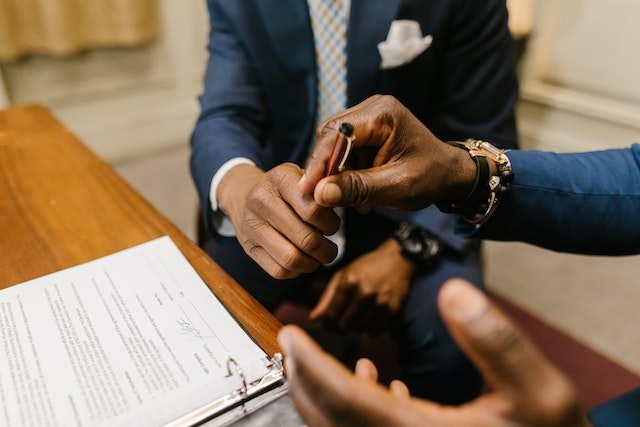 person in suit signing a contract