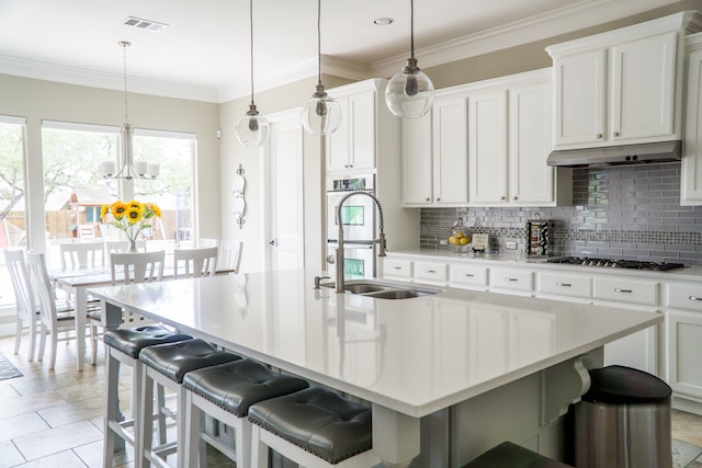 white-modern-kitchen-with-large-granite-countertop-island